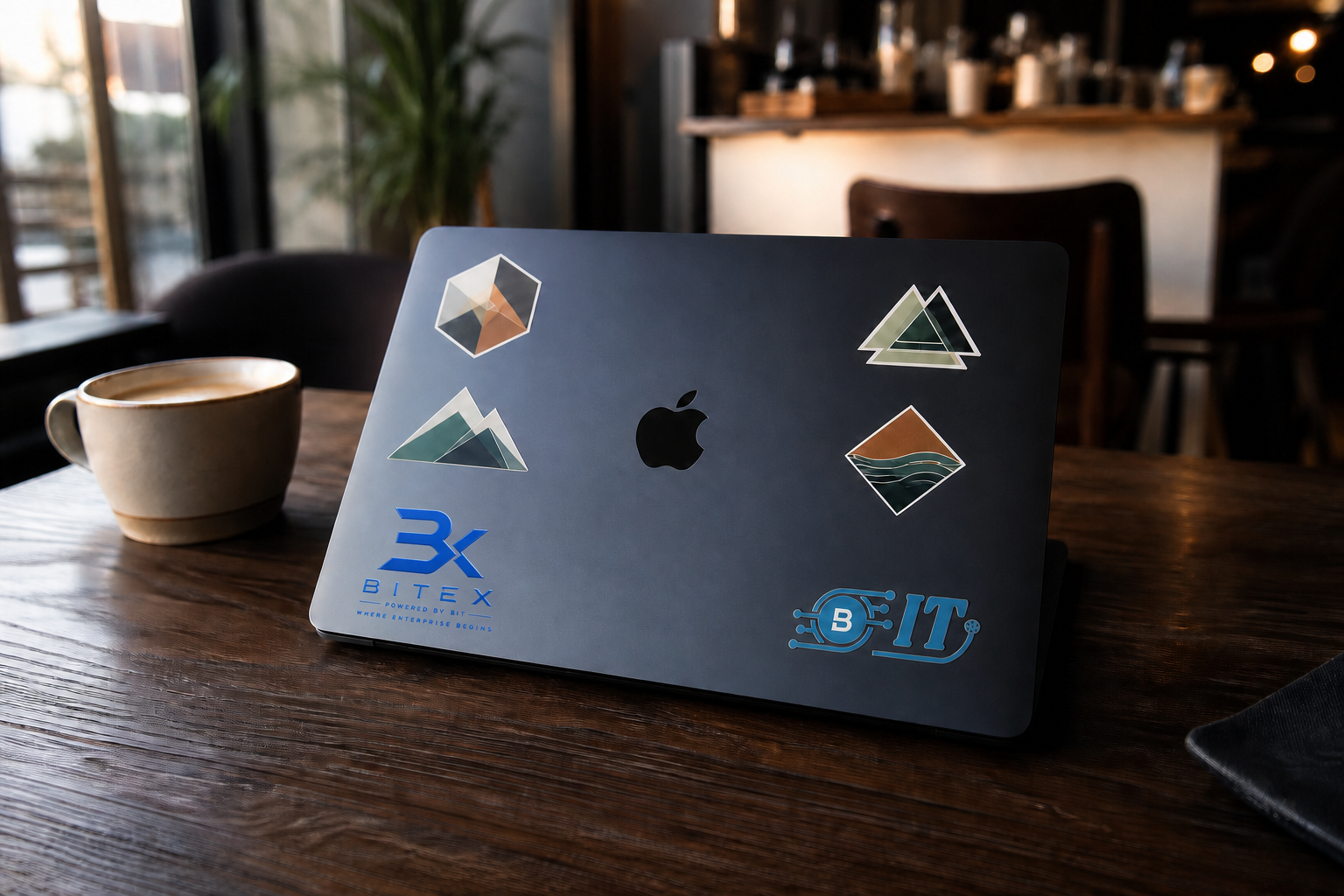 A branded Midnight MacBook on a warm café table beside coffee